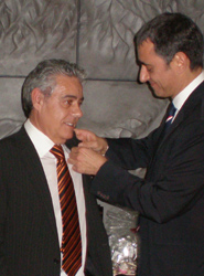 El presidente del Gremio, imponiendo la insignia de honor.